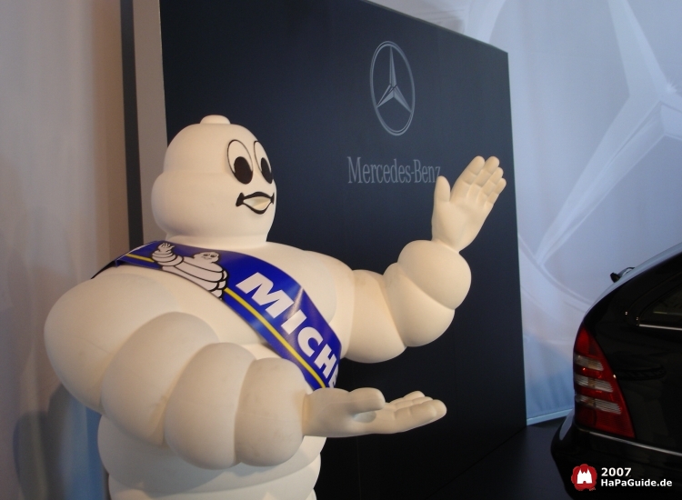 Michelin-Männchen vor einem Mercedes Plakat