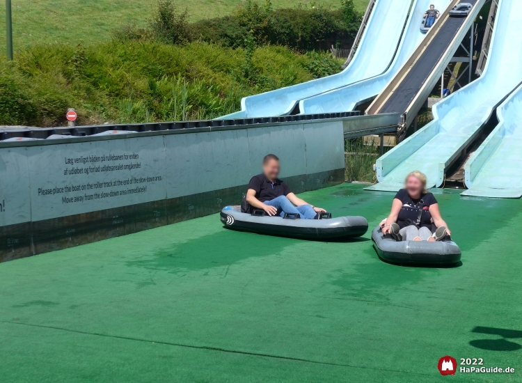 Zwei Fahrgäste lachen vergnügt im Auslaufbereich Barracuda Slides