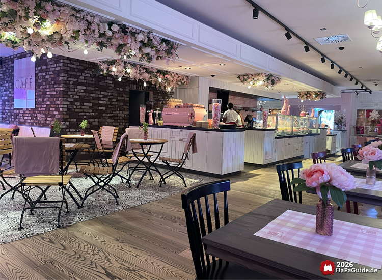 Stilvoll dekoriertes Café Rosa mit Blumenarrangements, Holzinterieur und pastellfarbener Einrichtung im Hansa-Park