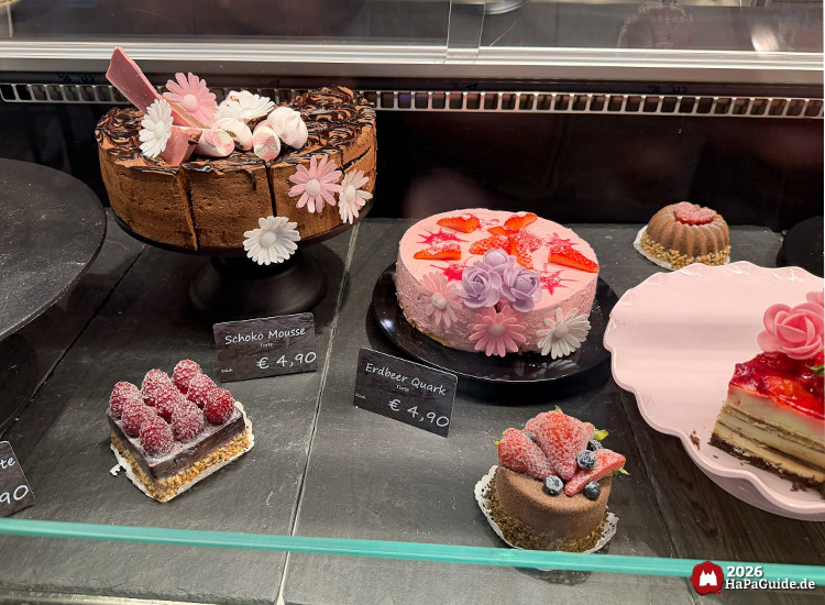 Kuchenvitrine im Café Rosa des Hansa-Parks mit kunstvoll dekorierten Torten und Gebäck wie Schoko-Mousse und Erdbeer-Quark