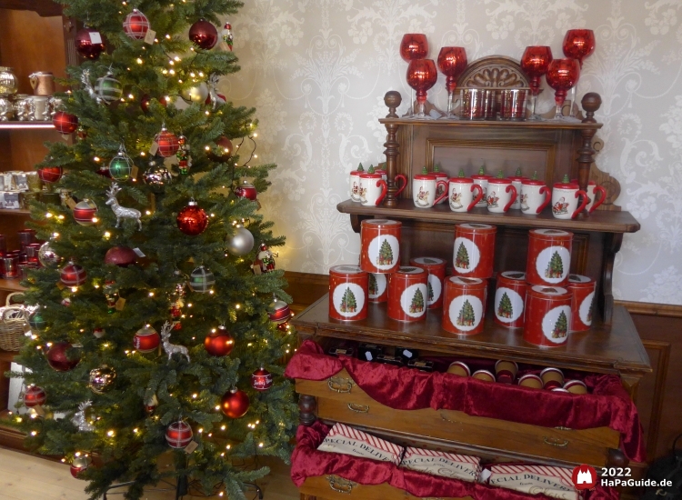 Dosen und Tassen neben einem dekorierten Weihnachtsbaum