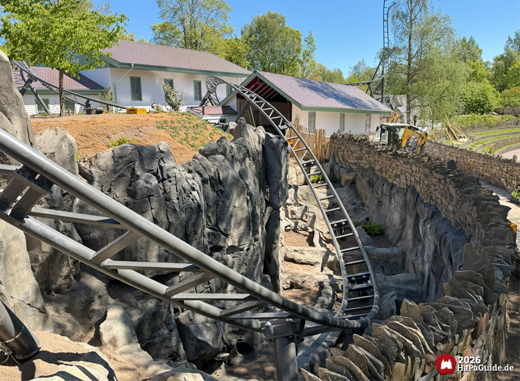 Cornwall Coaster im Hansa-Park: schwarze Achterbahnschiene verläuft durch künstliche Felsenlandschaft vor hellen Gebäuden und grünem Baumbestand, Foto Mai 2026 von HaPaGuide.de