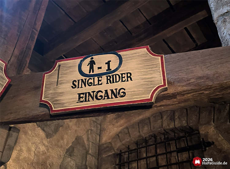 Single Rider Eingang im Hansa Park, hölzernes Schild mit Piktogramm und Hinweis für Einzel¬fahrer bei Flucht von Novgorod