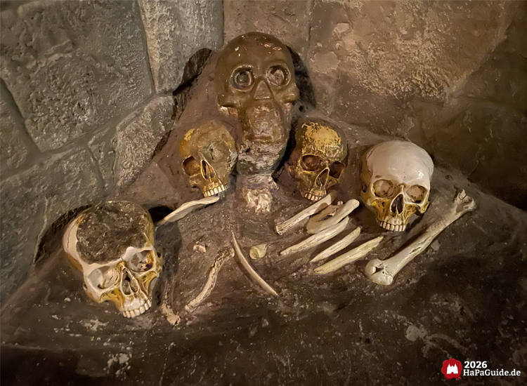 Skelett  und Schädel¬haufen im Hansa Park, archäologisch inszenierte Knochenfunde als thematische Dekoration der Flucht von Novgorod