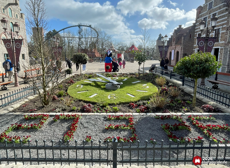 Blumenuhr im Hansa-Park mit großer grüner Uhr, Blumenmotiv und Besuchenden im Hintergrund