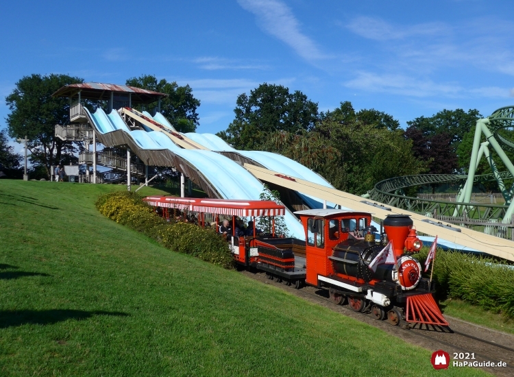 Der Hansa-Park Express fährt entlang der Wasserwellenbahn Barracuda Slide