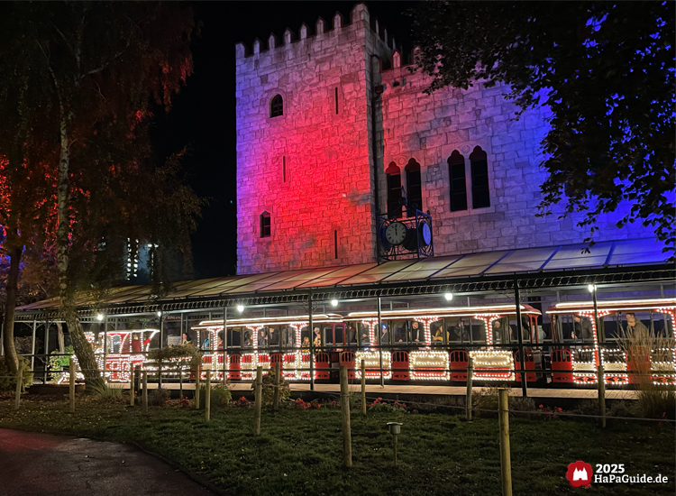 Hansa-Park Express - Seitenansicht des Hauptbahnhofs Hansa-Garten mit dem beleuchteten Lichterzug