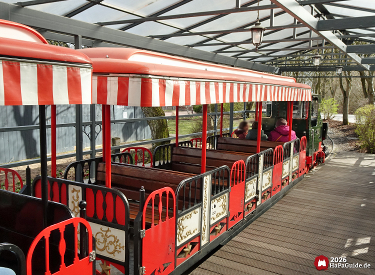 Der Hansa-Park Express mit offenen rot weißen Waggons unter dem Glasdach des Hauptbahnhofs Hansa-Garten im Hansa-Park