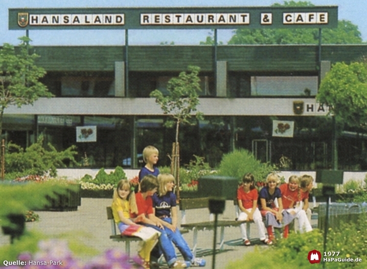 Kinder sitzen auf Bänken vor dem Hansaland Restaurant und Café