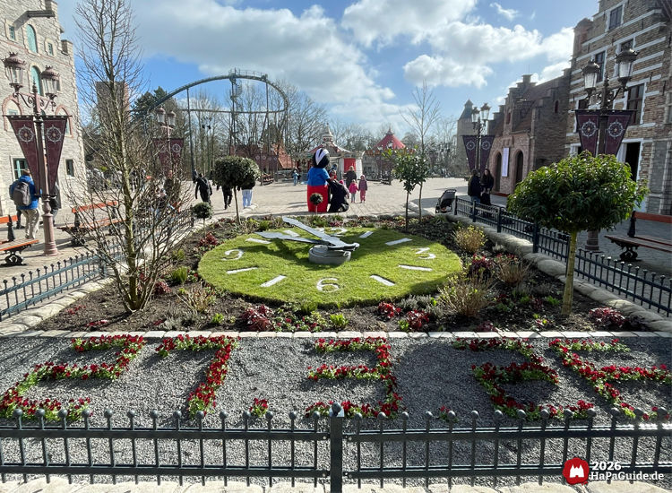 Große Blumenuhr mit Ziffern und Metallzeigern im dekorativen Eingangsbereich des Hansa-Park