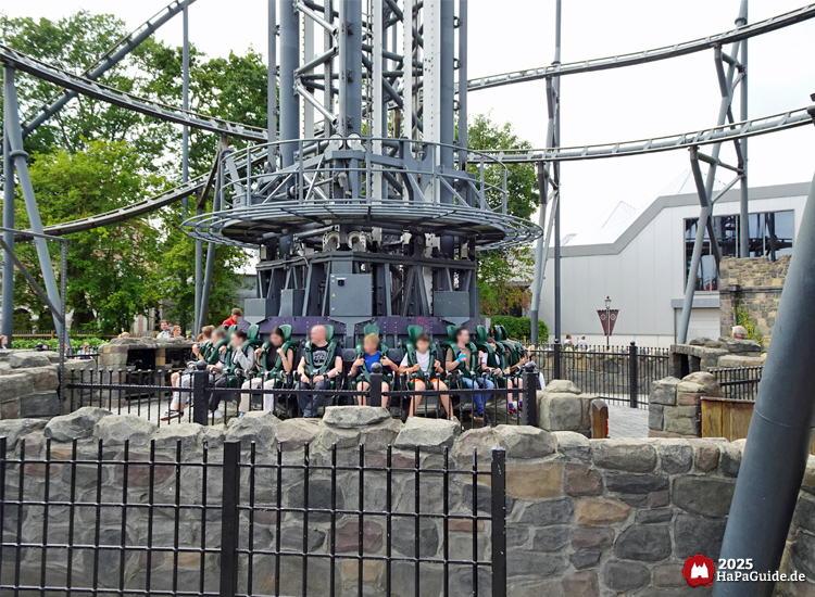 Highlander - Fahrgäste warten hinter Steinmauern auf die Abfahrt