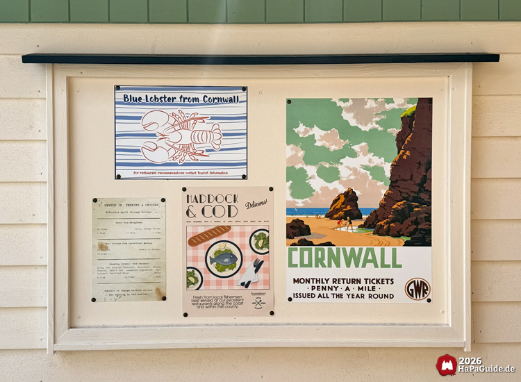 Infotafel am Ausgang des Cornwall Coasters im Hansa-Park mit Vintage-Postern zu Cornwall, darunter Blue Lobster, Haddock und Cod und GWR-Reiseplakat, helle Holzverkleidung