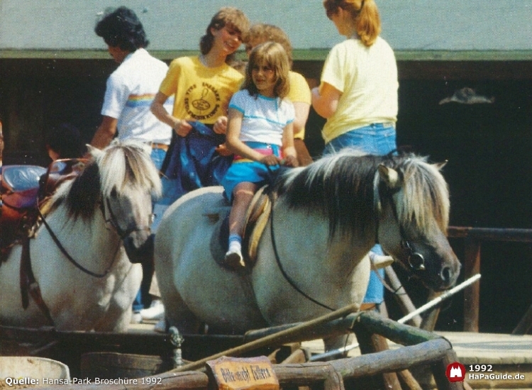 Ein Mädchen wartet auf dem Rücken ihres Ponys auf den Ausritt durch Bonanza City