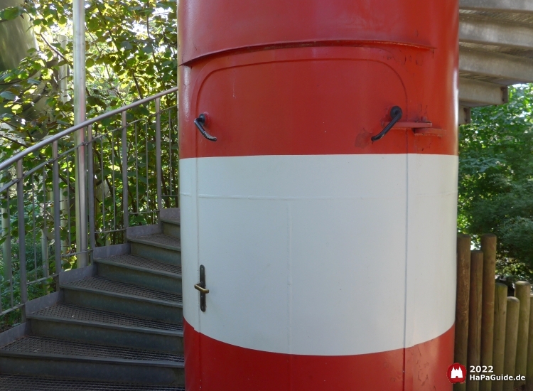 Am Aufgang liegt eine Tür in dem rot-weißen Leuchtturm