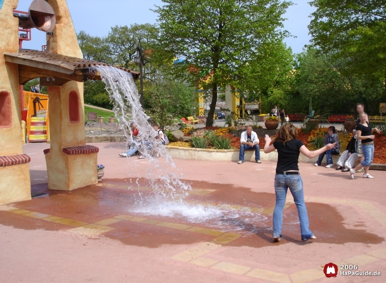 Wassermassen stürzen vor einer Frau vom Dach der Spanischen Glocke