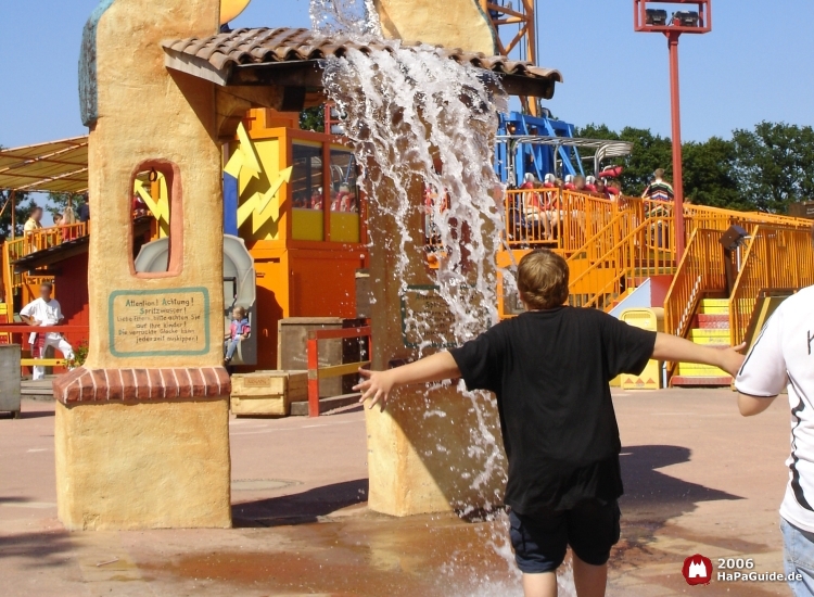Ein Junge streckt seine Arme aus während das Wasser der Spanischen Glocke ausschüttet