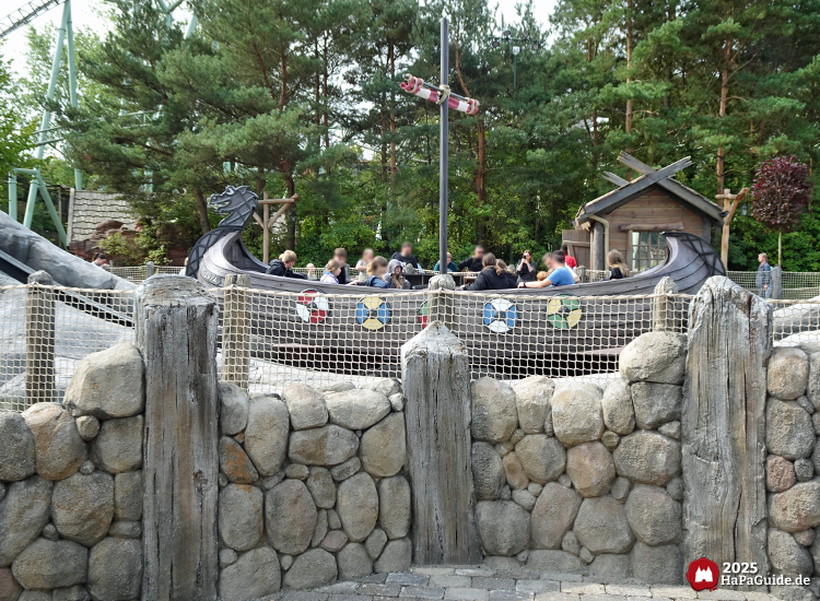 Wikingerland - Drachenboot von Einars Fjordfahrt hinter einer Steinwand